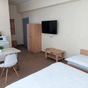 um quarto com 2 camas e uma televisão de ecrã plano em Fermelor Residence em Piatra Neamţ