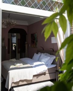 1 dormitorio con 1 cama con sábanas y almohadas blancas en Suite 137, luxe verblijf midden in de bollenstreek en Lisse