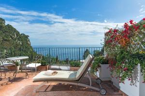 a balcony with a chair and a table and flowers at Hotel Della Piccola Marina in Capri