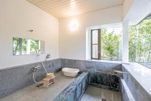 伊豆市にある天然温泉&絶景露天風呂付き貸切宿のんびり一非日常空間を愉しむ一10人でも広々のバスルーム(トイレ付)、窓が備わります。