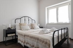 una camera bianca con un grande letto con asciugamani di Ostriche - YourPlace Abruzzo a Torino di Sangro