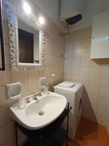 Un baño con lavabo y lavadora. en Mediterranea, en Cannigione