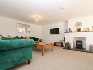a living room with a green couch and a table at Furness in St Austell