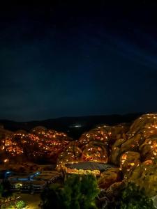 a view of a city at night with lights at Little Petra Bedouin Camp in Al Ḩayy