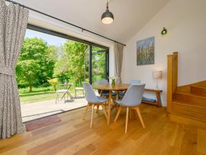 a dining room with a table and chairs and a large window at Bluebell Cottage in Tavistock