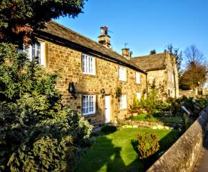 an old brick house with a garden in front of it at Maywalk House B&B in Eyam