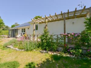 a house with a fence and flowers in the yard at Bluebell Cottage in Tavistock