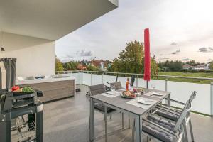 a patio with a table and chairs on a balcony at Luxus_SPA_OG_Fewo DREAMTIME _WE 3_ in Göhren-Lebbin