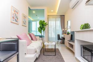 a living room with a white couch and a fireplace at Navi Vt-ara36 Condo in Bangkok