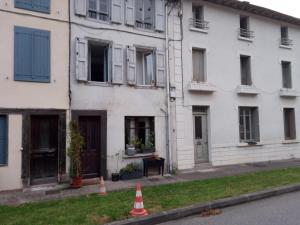 Castelnau-DurbanTiny Studio Ariège Pyrénées的一座白色的建筑,前面设有窗户和橙色锥形