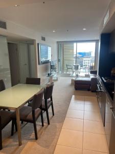 uma cozinha e sala de estar com mesa e cadeiras em 2br ANTEA Embassy free parking em Adelaide