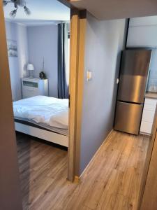 a small bedroom with a bed and a refrigerator at 2- pokojowe mieszkanie w Gdyni Cisowa in Gdynia