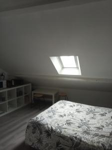 a bedroom with a bed and a window at Sous les toits de Dinan in Dinan