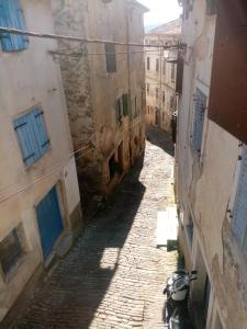 eine Gasse mit einem Motorrad in einer Gasse zwischen zwei Gebäuden in der Unterkunft Rooms Serafin in Motovun