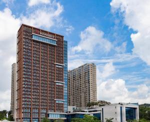 a tall building in front of two other buildings at Zhuhai Marriott Hotel in Zhuhai