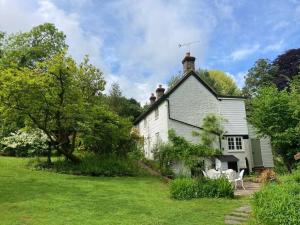 una vieja casa blanca con un patio de césped en Ashdown Forest character cottage, 18th Century en Crowborough