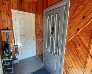 una puerta abierta en una habitación con paredes de madera en Ausros 19 flat en Utena