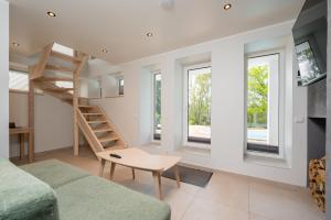 a living room with a staircase and a couch at Kalda Villa 