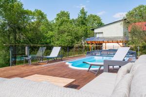 eine Terrasse mit Stühlen und einem Pool in der Unterkunft Kalda Villa 