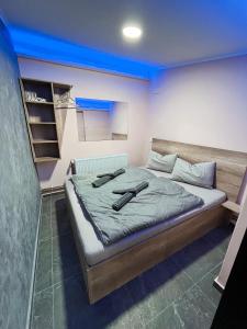 Un dormitorio con una cama con dos controladores. en KK Apartment Bajša 