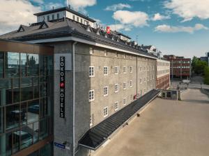 a large brick building next to a building at Original Sokos Hotel Villa Tampere in Tampere