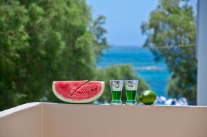 a slice of watermelon and two glasses of watermelon juice at Kavourakia in Agios Prokopios