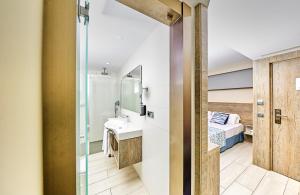 a bathroom with a sink and a bed in a room at Leonardo Royal Hotel Mallorca Palmanova Bay in Palmanova