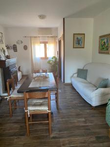 een woonkamer met een tafel en een bank bij Casa Vittoria in Palau