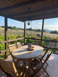 een houten tafel en stoelen op een veranda met uitzicht bij Casa Vittoria in Palau