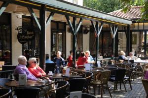 un grupo de personas sentadas en las mesas fuera de un restaurante en Hotel 't Spijker en Beek