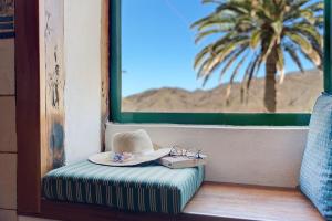 a hat and glasses sitting on a window seat at Rosa del Negro in Alojera