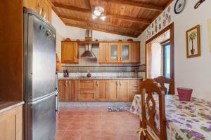 a kitchen with wooden cabinets and a stainless steel refrigerator at Rosa del Negro in Alojera