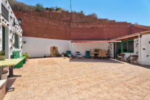 a patio with chairs and tables in a building at Rosa del Negro in Alojera