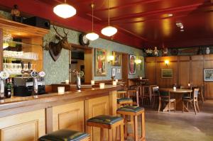 a bar in a restaurant with tables and chairs at Hotel 't Spijker in Beek