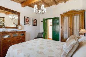 a bedroom with a bed and a dresser and a mirror at Rosa del Negro in Alojera