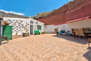 a patio with a table and chairs and a building at Rosa del Negro in Alojera
