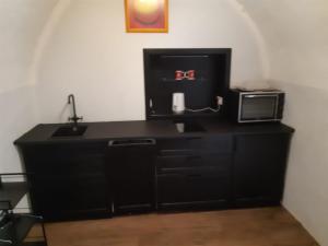 een zwart bureau met een wastafel en een magnetron bij Stadtresidenz Salburg in Klagenfurt