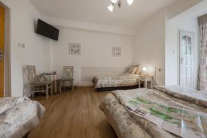 a bedroom with two beds and a table and a chair at Willa Wincentówka w sercu Uzdrowiska in Szczawnica