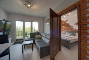 una sala de estar con un sofá y una cama en Lodz4rent - Premium Apartments 9,6 - MANUFAKTURA D77 - Parking w cenie, en Łódź