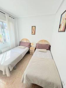 - 2 lits jumeaux dans une chambre avec fenêtre dans l'établissement Villa Oasis, à Ciudad Quesada