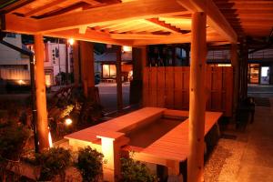 a wooden bench sitting under a pergola at night at Minoya in Yahiko