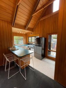 a kitchen with a table and a refrigerator in a room at Ski Pad Methven in Methven