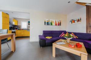 a living room with a purple couch and a table at Ferienhaus Hödur in Hasselfelde +19 photos