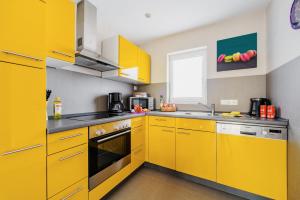 a yellow kitchen with a sink and a stove at Ferienhaus Hödur in Hasselfelde