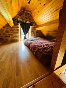 a bed in a room with a wooden ceiling at Studio au calme avec piscine partagée in Saint-Martin-la-Méanne