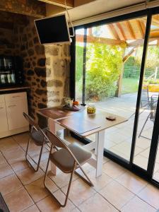 a kitchen with a table and chairs and a television at Studio au calme avec piscine partagée in Saint-Martin-la-Méanne