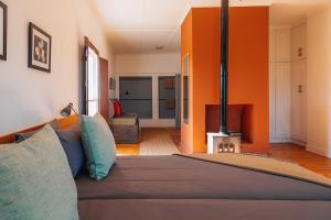 a bedroom with a bed with an orange wall at Farm 215 Private Nature Reserve in Uilenkraal
