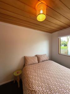 a bedroom with a bed with a wooden ceiling at Ski Pad Methven in Methven