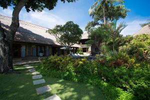 a house with a garden in front of it at The Royal Beach Seminyak Bali in Seminyak
