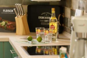 a bottle of alcohol and two glasses on a counter at Premium-Plus-Ferienhaus Havanna Select in Hasselfelde